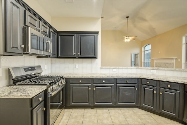 10900 Spruce Dr N, La Porte, TX 77571 - kitchen featuring appliances with stainless steel finishes, tasteful backsplash, light tile patterned floors, ceiling fan, and lofted ceiling