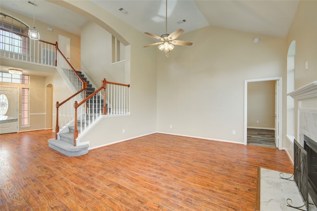 10900 Spruce Dr N, La Porte, TX 77571 - unfurnished living room featuring high vaulted ceiling, stairs, wood finished floors, a ceiling fan, and arched walkways