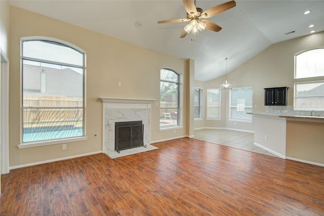10900 Spruce Dr N, La Porte, TX 77571 - unfurnished living room with wood finished floors, a fireplace, lofted ceiling, a ceiling fan, and baseboards