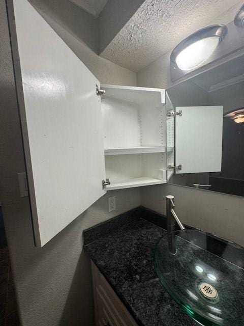 bathroom featuring a textured ceiling and vanity