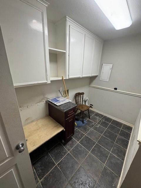 clothes washing area with dark tile patterned flooring
