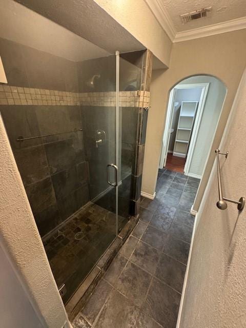 bathroom featuring crown molding, a shower stall, and baseboards