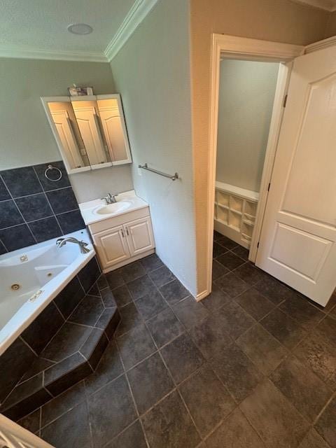 bathroom featuring crown molding, vanity, tile patterned floors, and a tub with jets