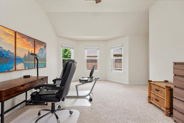 carpeted home office with vaulted ceiling and baseboards