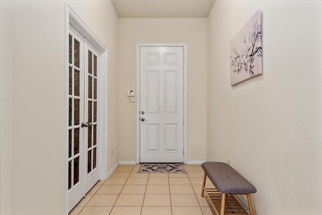 doorway to outside featuring french doors, light tile patterned floors, and baseboards