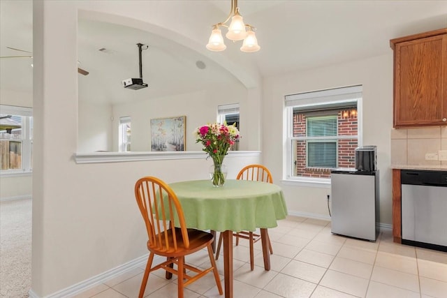 dining area with a chandelier, baseboards, and light tile patterned floors