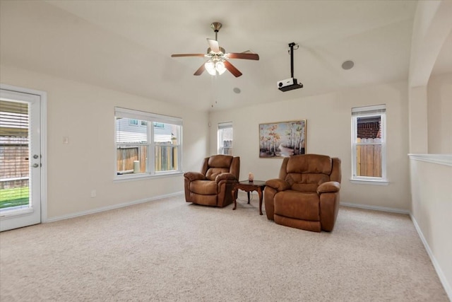 living area featuring carpet flooring, a ceiling fan, lofted ceiling, and baseboards