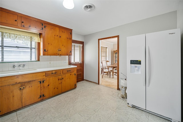 5402 Tallow Ln, Houston, TX 77021 - kitchen with white fridge with ice dispenser, a sink, light countertops, brown cabinets, and light floors