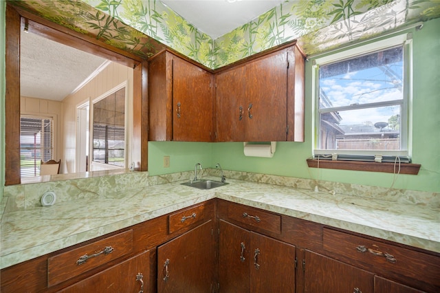 5402 Tallow Ln, Houston, TX 77021 - kitchen featuring a sink, light countertops, a textured ceiling, and wallpapered walls
