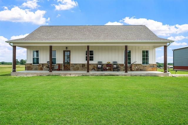 3785 County Road 405, Anderson, TX 77830 - rear view of house with a yard, stone siding, a shingled roof, and a patio area