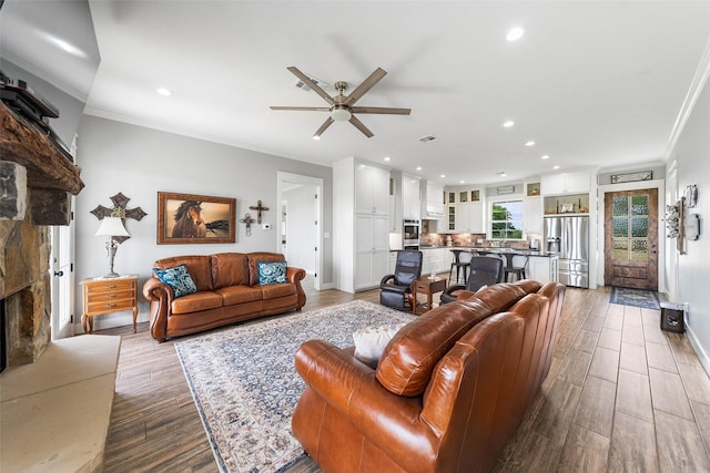 3785 County Road 405, Anderson, TX 77830 - living area featuring a ceiling fan, ornamental molding, a stone fireplace, wood finished floors, and baseboards