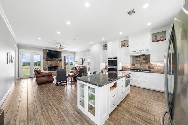 3785 County Road 405, Anderson, TX 77830 - kitchen with appliances with stainless steel finishes, a stone fireplace, crown molding, decorative backsplash, and open floor plan