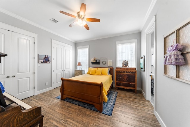 3785 County Road 405, Anderson, TX 77830 - bedroom with multiple closets, baseboards, wood finished floors, crown molding, and a ceiling fan
