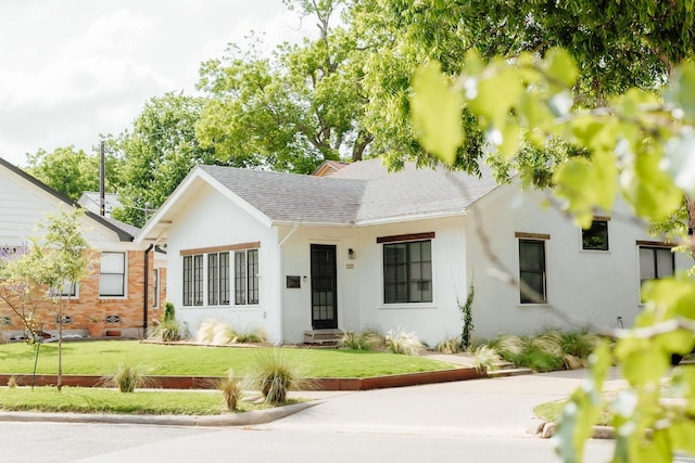 713 Usener St, Houston, TX 77009 - view of front of property with roof with shingles, a front lawn, and stucco siding