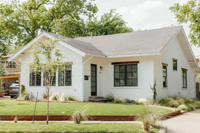 713 Usener St, Houston, TX 77009 - view of front of home featuring a shingled roof, a front yard, and stucco siding