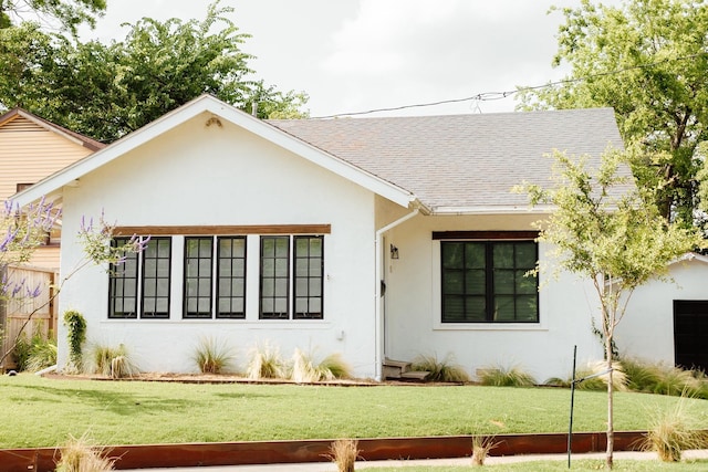 713 Usener St, Houston, TX 77009 - view of front facade with stucco siding, roof with shingles, and a front yard
