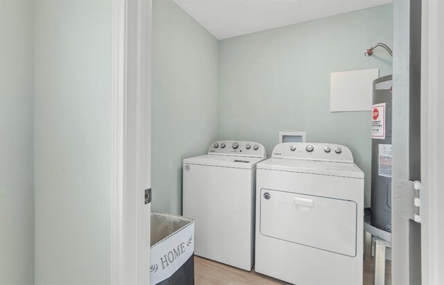 1019 Treaty Dr, Surfside Beach, TX 77541 - clothes washing area with independent washer and dryer and light wood-style floors