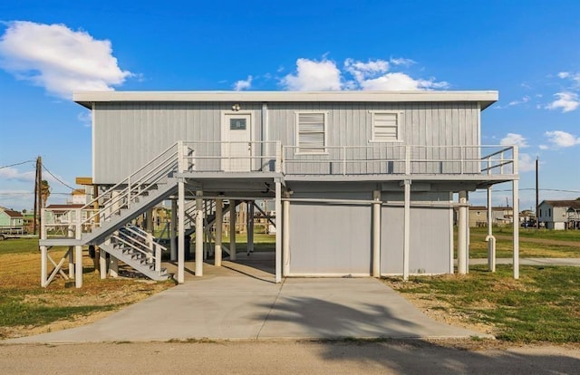 1019 Treaty Dr, Surfside Beach, TX 77541 - view of front facade featuring a carport, a front yard, and stairway