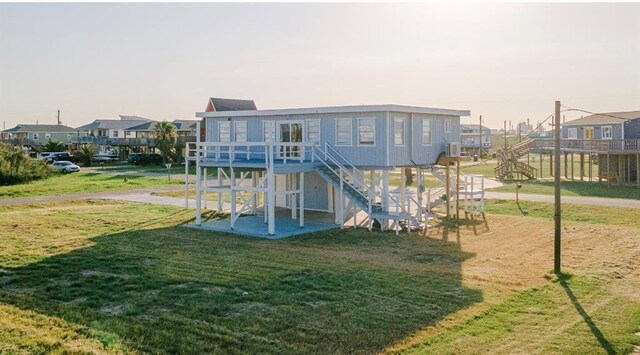 1019 Treaty Dr, Surfside Beach, TX 77541 - rear view of house with stairs, a residential view, a yard, and a deck