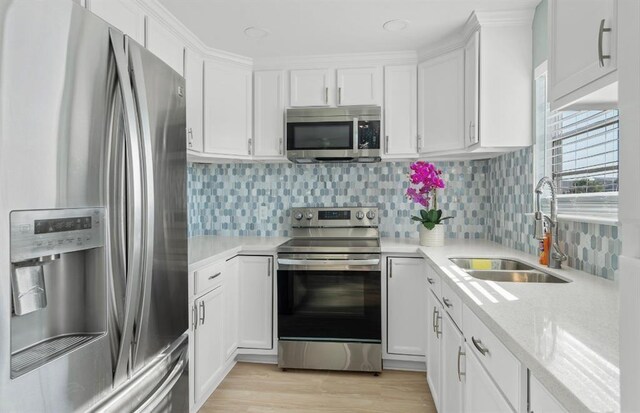 1019 Treaty Dr, Surfside Beach, TX 77541 - kitchen featuring stainless steel appliances, a sink, white cabinetry, and tasteful backsplash