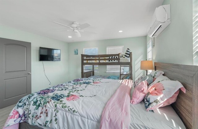 1019 Treaty Dr, Surfside Beach, TX 77541 - bedroom with a wall unit AC, wood finished floors, recessed lighting, and a ceiling fan