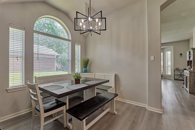 3729 Breckenridge Dr, Montgomery, TX 77356 - dining area featuring baseboards, wood finished floors, vaulted ceiling, and a chandelier