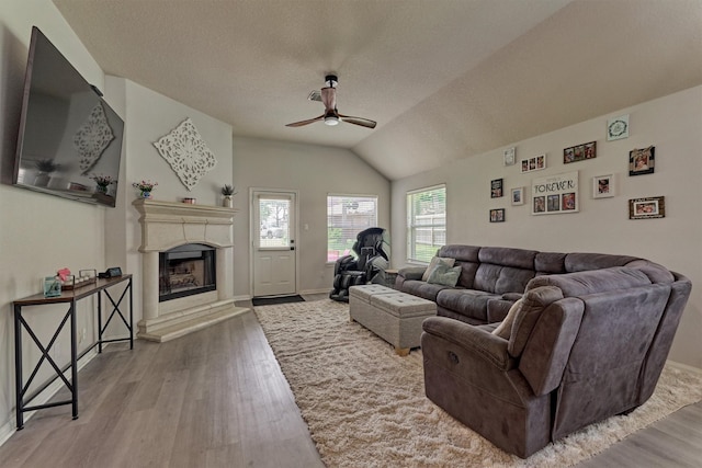 3729 Breckenridge Dr, Montgomery, TX 77356 - living area with ceiling fan, wood finished floors, a fireplace with raised hearth, lofted ceiling, and a textured ceiling