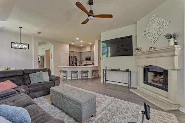 3729 Breckenridge Dr, Montgomery, TX 77356 - living room with a ceiling fan, wood finished floors, a fireplace with raised hearth, arched walkways, and recessed lighting
