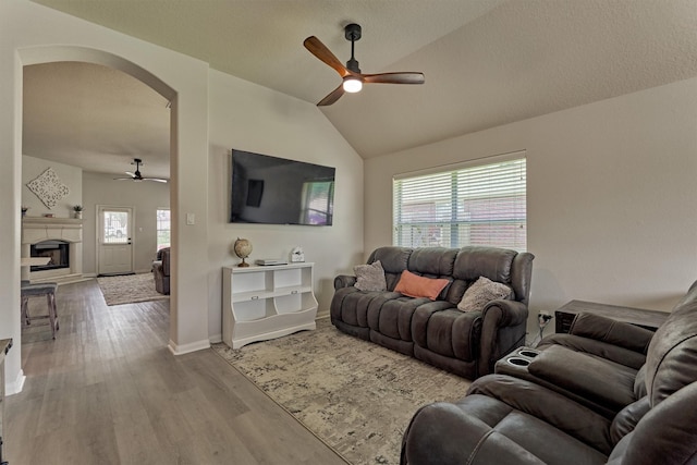 3729 Breckenridge Dr, Montgomery, TX 77356 - living room with ceiling fan, arched walkways, wood finished floors, lofted ceiling, and a fireplace with raised hearth