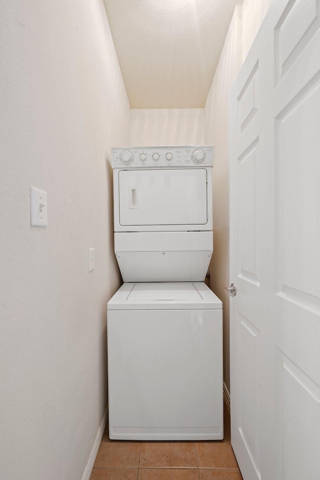 1001 Krenek Tap Rd Unit 1501, College Station, TX 77840 - laundry area featuring stacked washer and clothes dryer, baseboards, and light tile patterned flooring