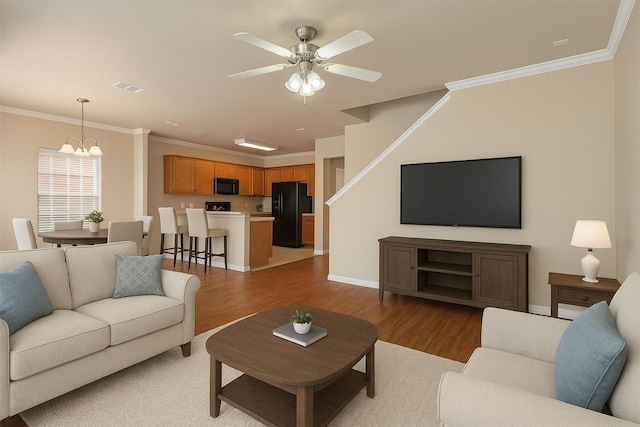 1001 Krenek Tap Rd Unit 1501, College Station, TX 77840 - living room with light wood-type flooring, a chandelier, ornamental molding, a ceiling fan, and baseboards