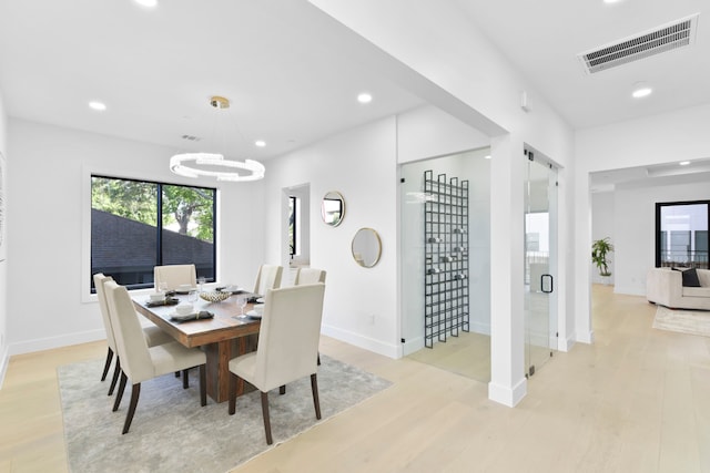 5115 Maple St, Houston, TX 77401 - dining room with light wood finished floors, a chandelier, recessed lighting, and baseboards