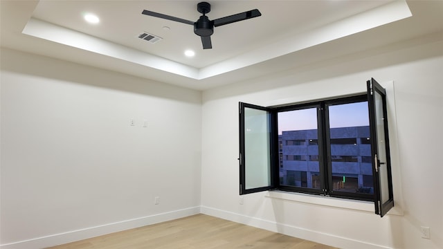 5115 Maple St, Houston, TX 77401 - empty room featuring light wood-style flooring, baseboards, ceiling fan, recessed lighting, and a tray ceiling
