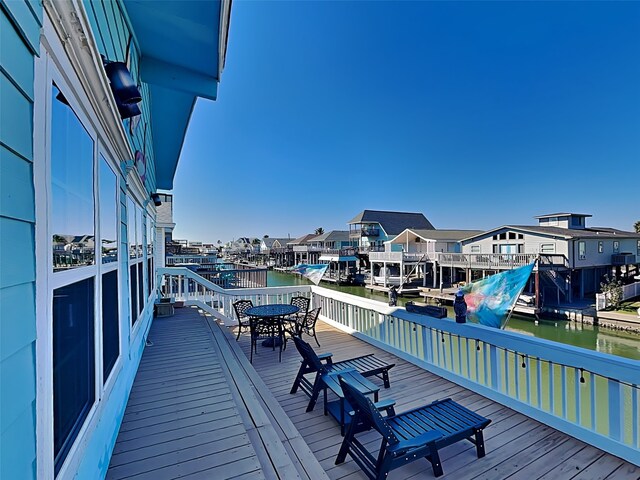22104 Zapata Dr, Galveston, TX 77554 - wooden terrace with a water view, outdoor dining space, and a residential view