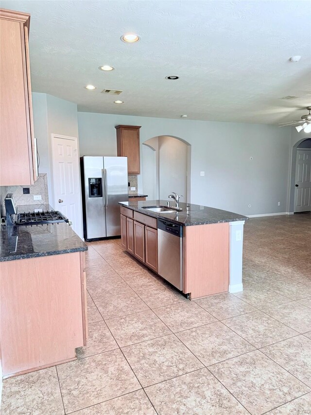 13938 Kenswick Key Ln, Houston, TX 77047 - kitchen with stainless steel appliances, arched walkways, a sink, dark stone countertops, and recessed lighting