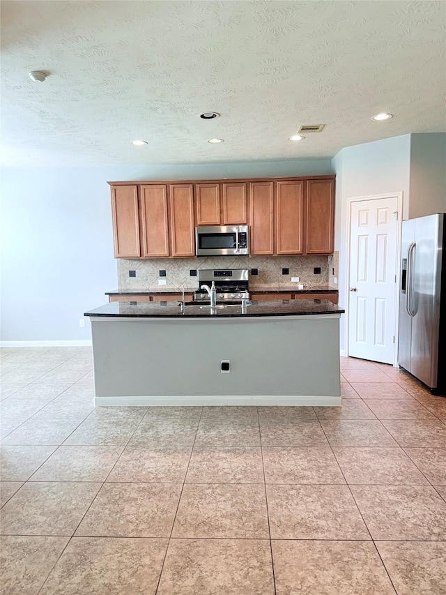 13938 Kenswick Key Ln, Houston, TX 77047 - kitchen featuring stainless steel appliances, decorative backsplash, dark countertops, a textured ceiling, and brown cabinets