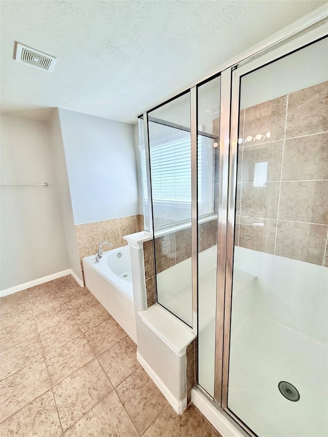 13938 Kenswick Key Ln, Houston, TX 77047 - full bathroom featuring a stall shower, a garden tub, baseboards, a textured ceiling, and tile patterned floors
