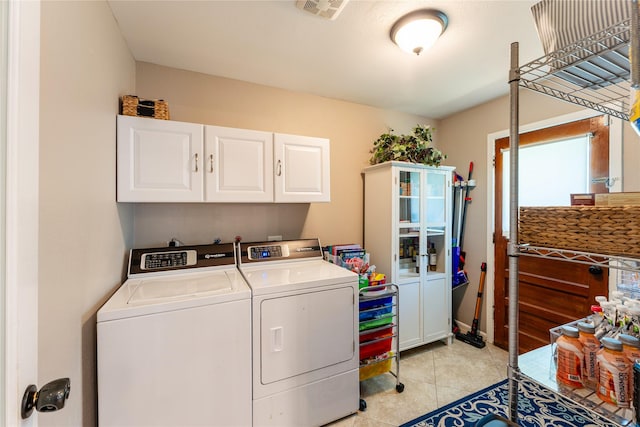 8914 Railton St, Houston, TX 77080 - laundry area with cabinet space, washer and clothes dryer, and light tile patterned flooring