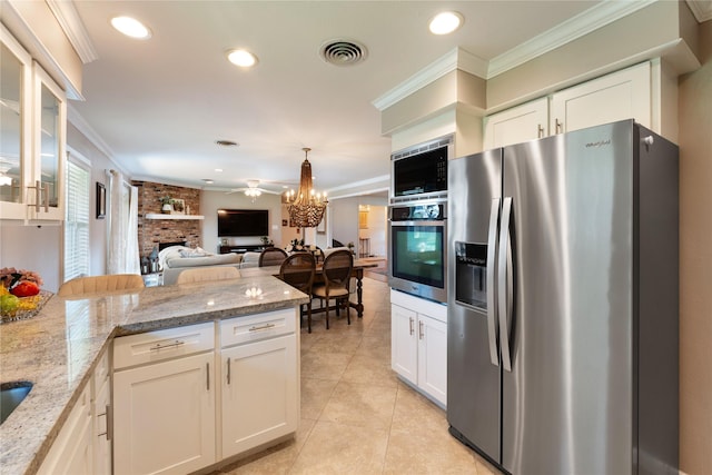 8914 Railton St, Houston, TX 77080 - kitchen with stainless steel appliances, a fireplace, a peninsula, light tile patterned floors, and white cabinets