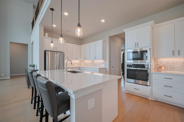 21714 Jenolan Ridge Rd, Cypress, TX 77433 - kitchen with stainless steel appliances, a sink, tasteful backsplash, light countertops, and recessed lighting