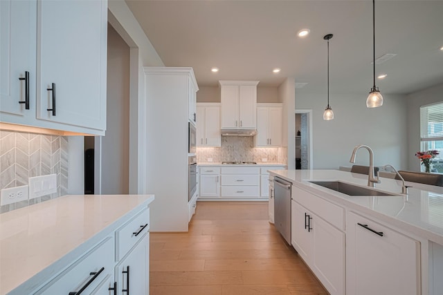 21714 Jenolan Ridge Rd, Cypress, TX 77433 - kitchen with a sink, stainless steel appliances, backsplash, light stone counters, and white cabinets