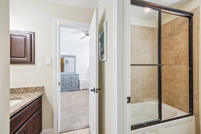 bathroom featuring bath / shower combo with glass door, vanity, and a ceiling fan