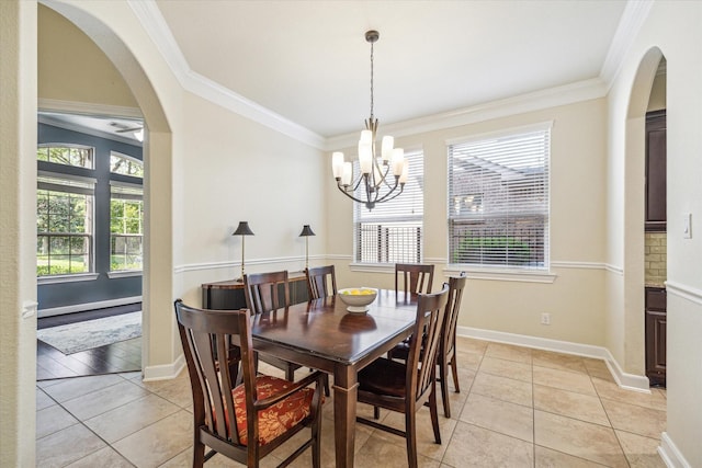 dining area featuring healthy amount of natural light, arched walkways, light tile patterned floors, and crown molding