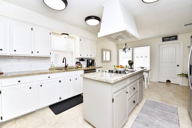 12007 Nova Dr, Houston, TX 77077 - kitchen featuring a sink, black electric cooktop, a kitchen island, white cabinets, and a chandelier