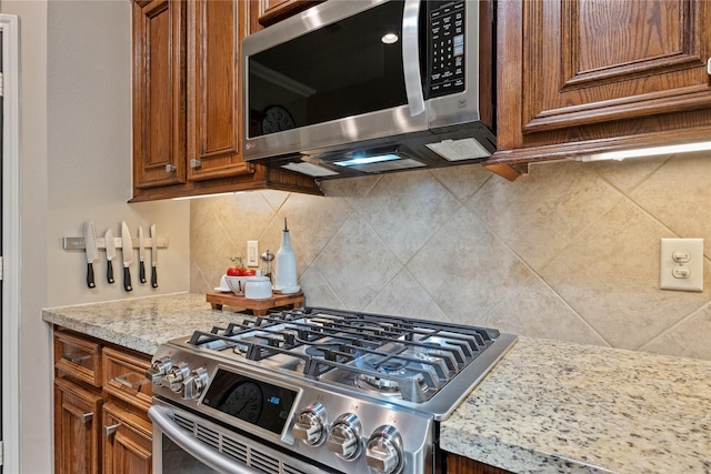 27438 Channing Springs Dr, Spring, TX 77386 - kitchen with stainless steel appliances, brown cabinets, and tasteful backsplash