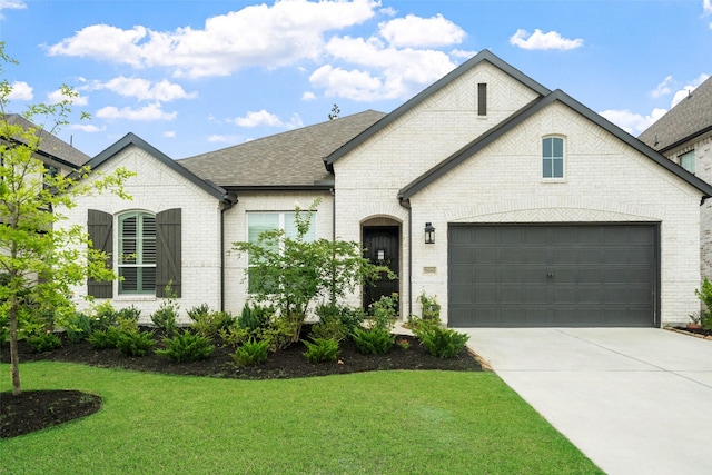 15040 Berry Brook Dr, Conroe, TX 77302 - french country inspired facade featuring brick siding, driveway, a front yard, roof with shingles, and an attached garage