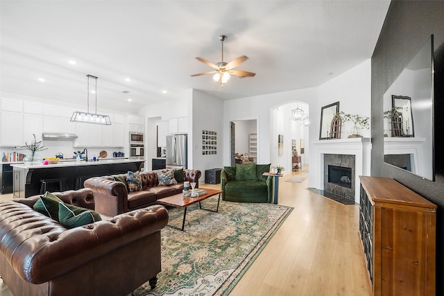 15040 Berry Brook Dr, Conroe, TX 77302 - living room featuring a ceiling fan, light wood-style flooring, vaulted ceiling, recessed lighting, and arched walkways