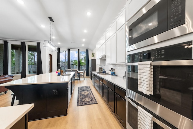 15040 Berry Brook Dr, Conroe, TX 77302 - kitchen featuring appliances with stainless steel finishes, light countertops, a sink, white cabinets, and recessed lighting
