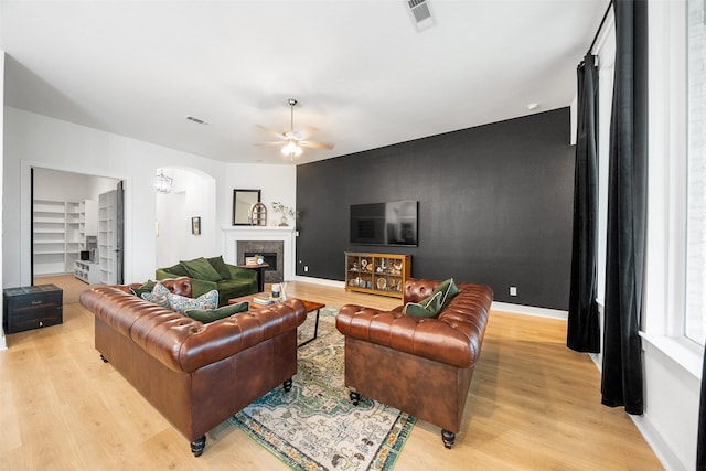 15040 Berry Brook Dr, Conroe, TX 77302 - living area featuring arched walkways, light wood-style floors, ceiling fan, and baseboards