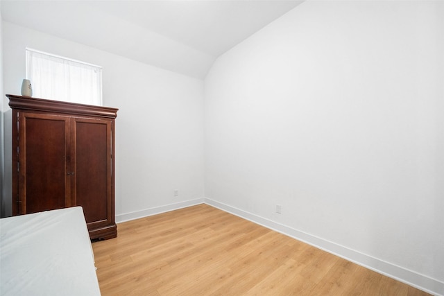 15040 Berry Brook Dr, Conroe, TX 77302 - unfurnished bedroom with light wood finished floors, baseboards, and lofted ceiling